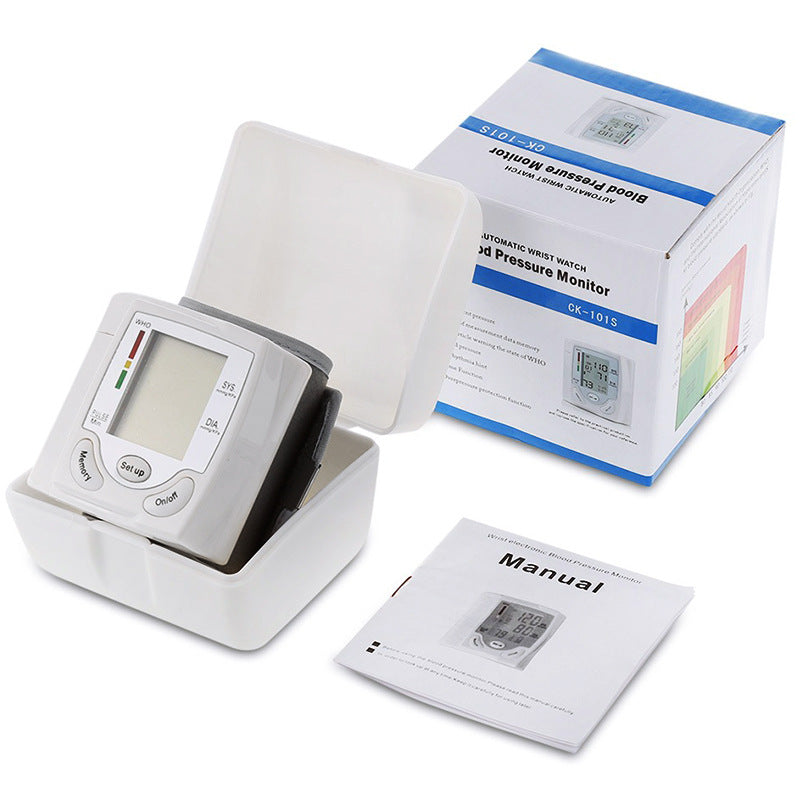 Blood pressure monitor with packaging and manual on a white background