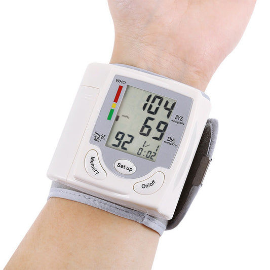 Wrist-mounted blood pressure monitor displaying readings on a white background