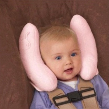 Baby wearing a pink Baby Head-Shaped Banana Pillow against a brown background