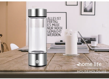 HydraPure™ Hydrogen Water Bottle with silver base on a wooden table, with 'home life' branding.