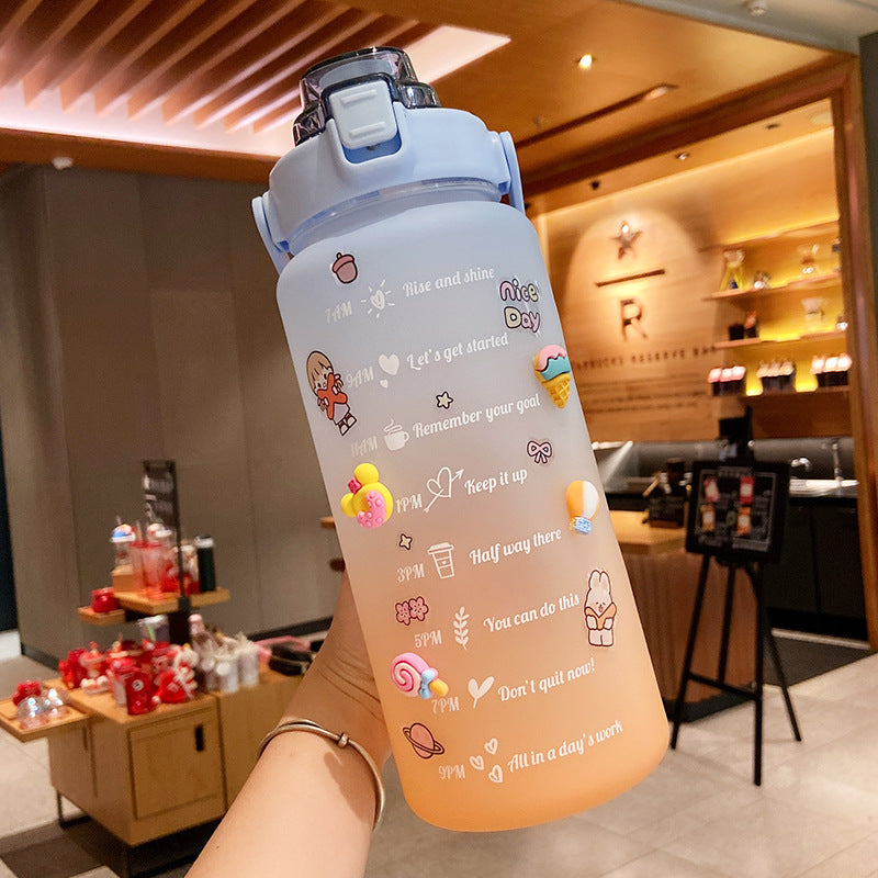 HydraTrack™ 2L Water Bottle with motivational phrases held in a store kitchen.